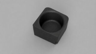 Small black square tray with a circular recessed well in the center, viewed from above